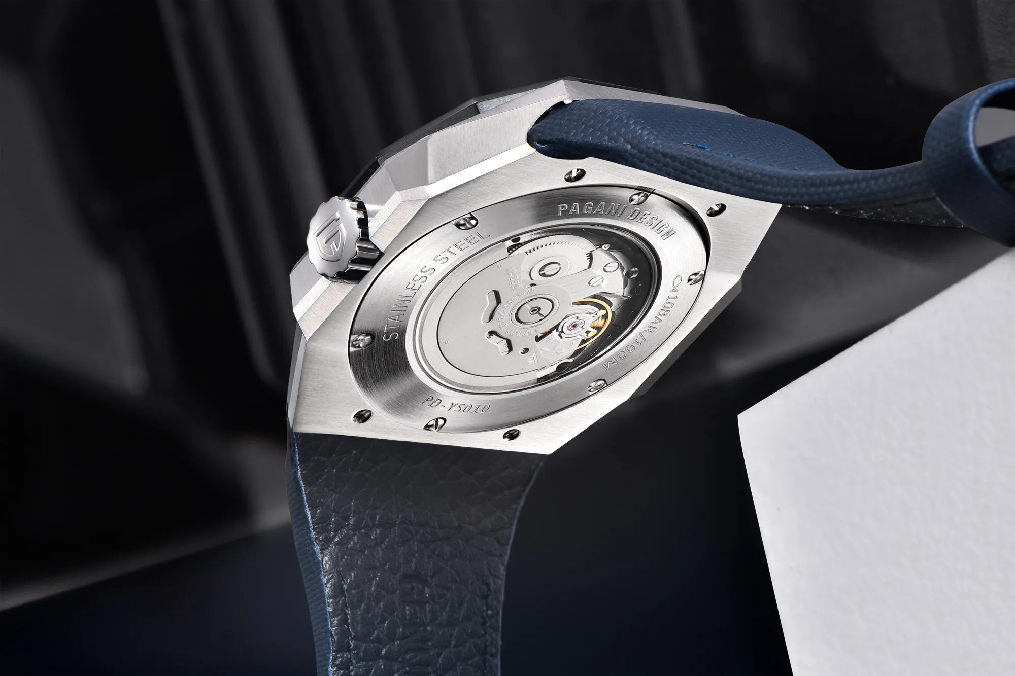 Close-up of a watch with a visible mechanical movement on a dark background
