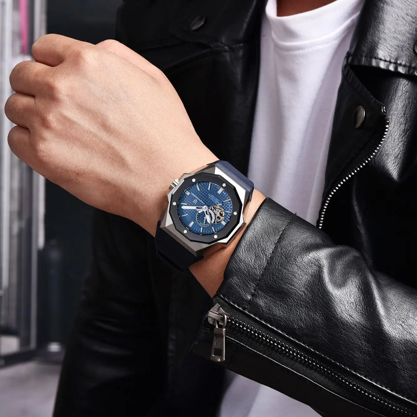 Person wearing a black leather jacket with a watch on their wrist.