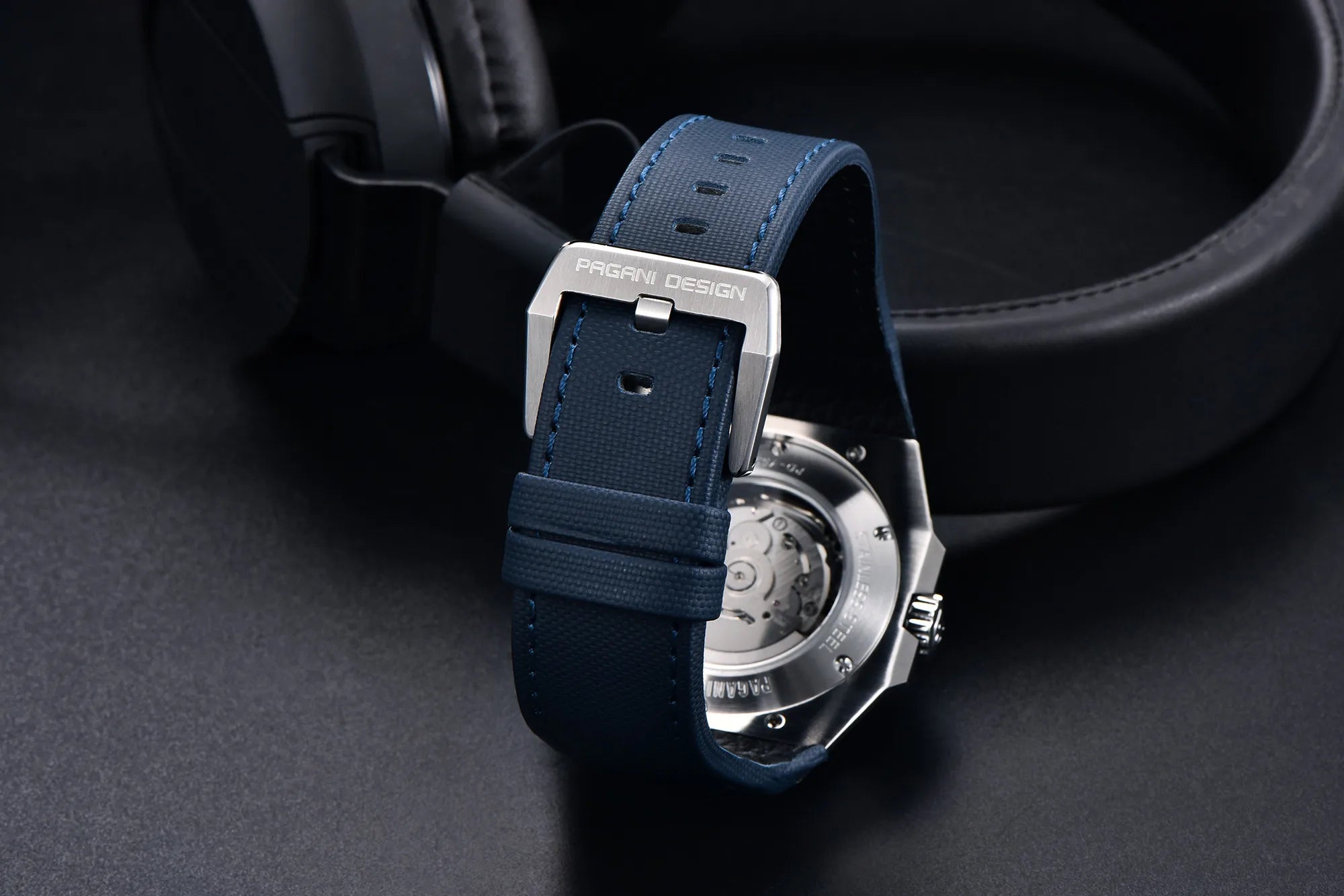 Watch with blue strap and silver case on a dark background